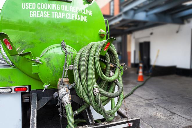 a technician pumping a grease trap in a commercial building in Bryn Mawr